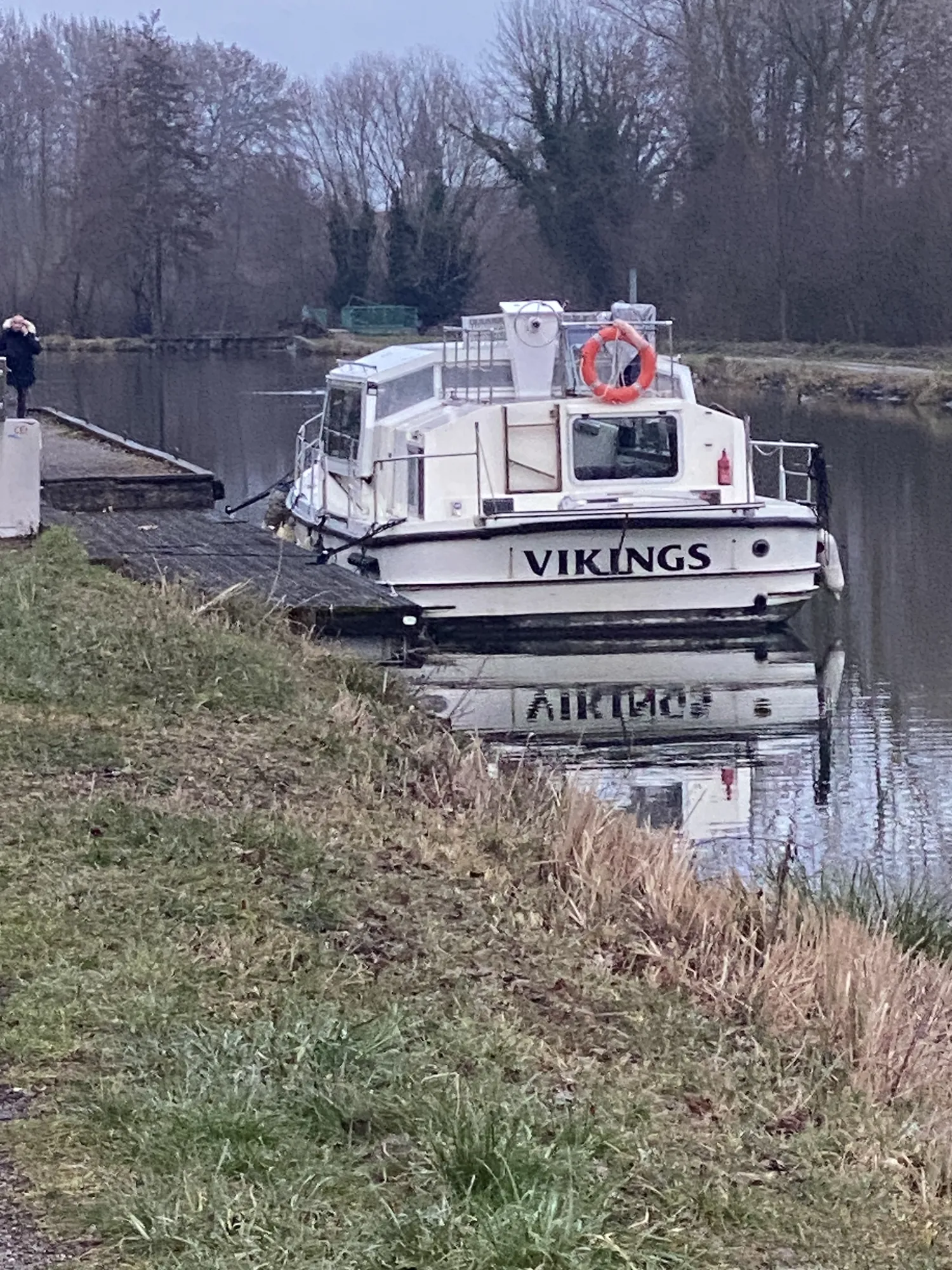Berge herbeuse de la Marne, promeneur sur le chemin le long de l'eau et bateau amarré au ponton